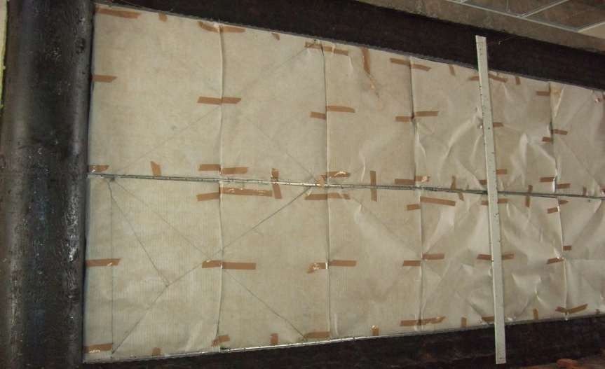 Acoustic insulation sheets being fixed to a wall before panelling