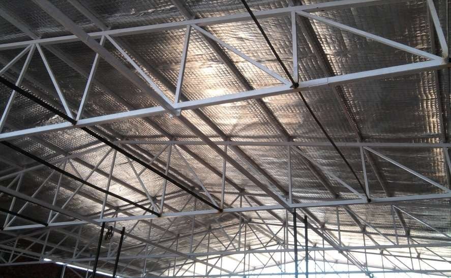 Reflective insulation fixed under a corrugated roof between steel trusses