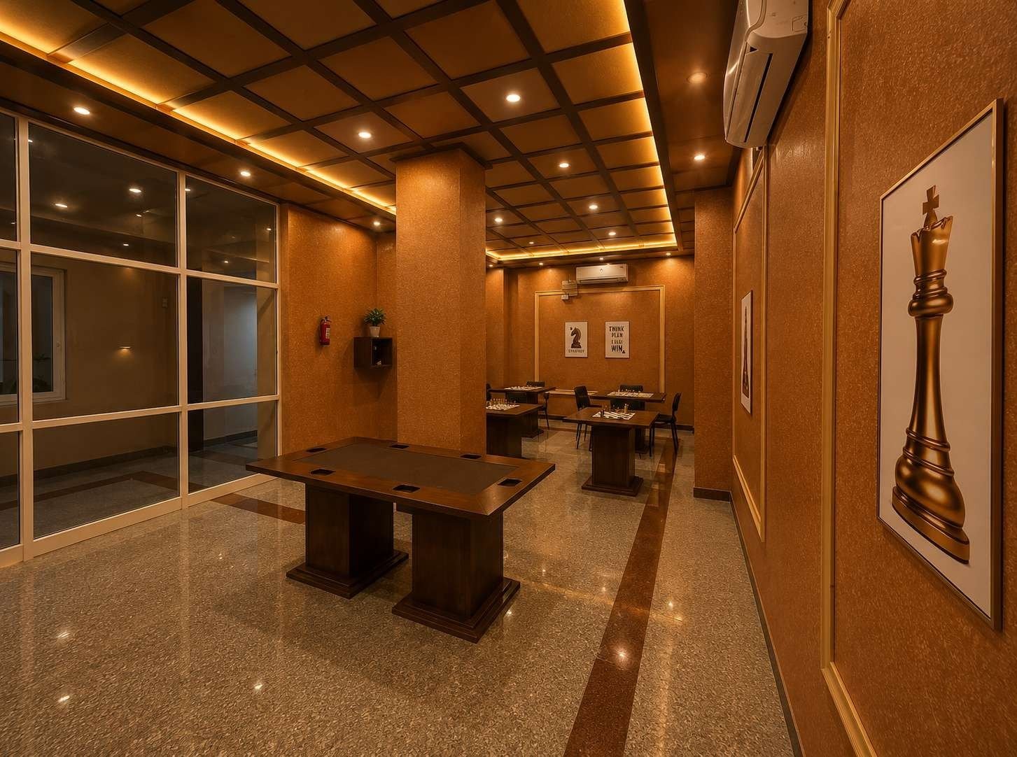 Club lounge at AIS Residency with game tables, glazed wall and chess-themed artwork