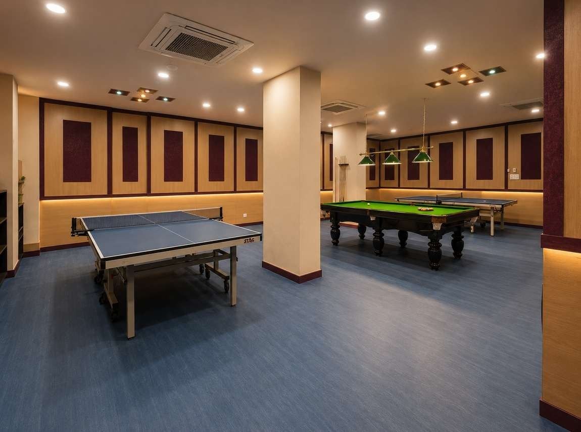 Games zone at AIS Residency with table tennis tables and a billiards table on blue flooring